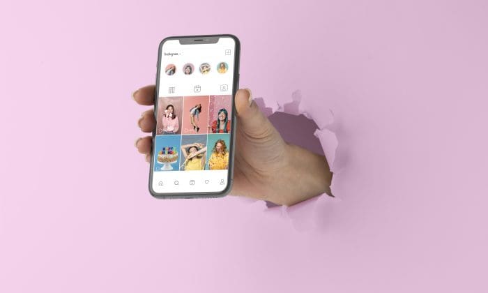 Hand standing out with phone that has Instagram open