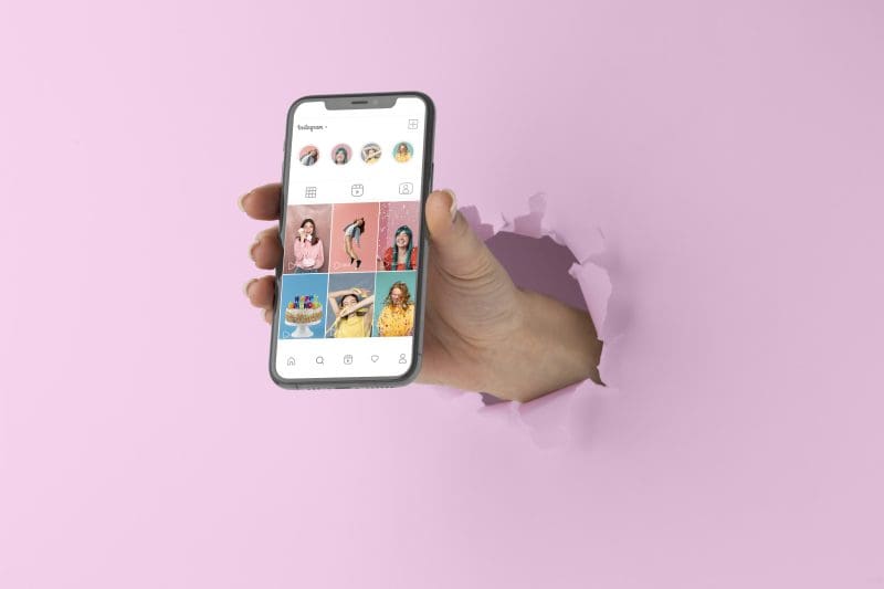 Hand standing out with phone that has Instagram open